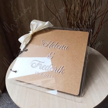 Akrylový svadobný fotoalbum s personalizovaným gravírovaním mien snúbencov a dátumom svadby – elegantný moderný dizajn so stuhou.