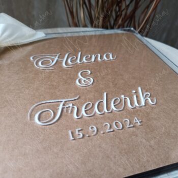 Akrylový svadobný fotoalbum s personalizovaným gravírovaním mien snúbencov a dátumom svadby – elegantný moderný dizajn so stuhou.