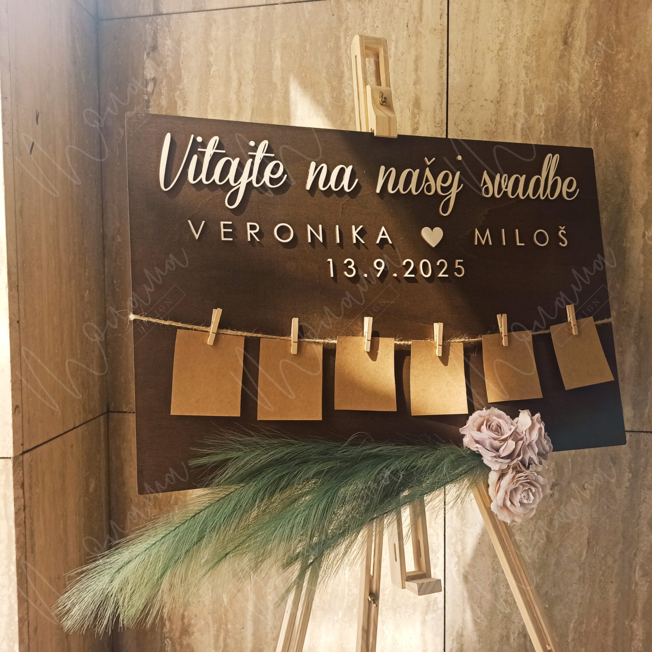Drevený zasadací poriadok na svadbu – tmavá tabuľa s nápisom Vitajte na našej svadbe, menami, dátumom a šnúrkou so štipcami na kartičky hostí