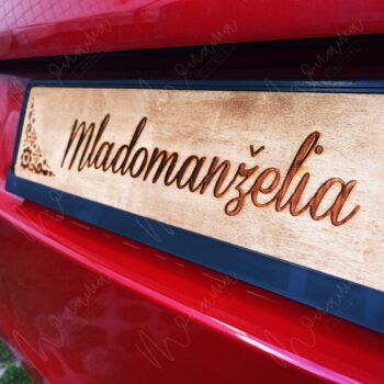 Svadobná tabuľa s nápisom Mladomanželia – drevená dekorácia na svadobné auto s gravírovaným folklórnym vzorom.