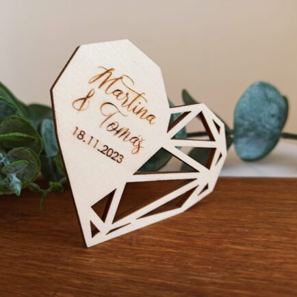 Drevená svadobná magnetka v tvare geometrického srdca s gravírovanými menami „Martina & Tomáš“ a dátumom svadby „18.11.2023“. Štýlový rustikálny svadobný darček pre hostí, vyrobený z kvalitného dreva s magnetom na zadnej strane. {{brizy_dc_image_alt imageSrc=
