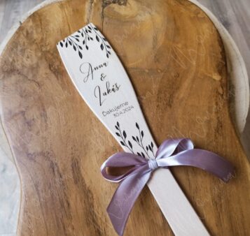 Drevená vareška s gravírovaným motívom a menami ozdobená saténovou stuhou.