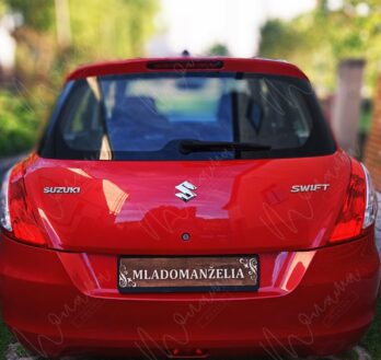 Drevená svadobná tabuľka ŠPZ s nápisom „Mladomanželia“ na červenom aute.