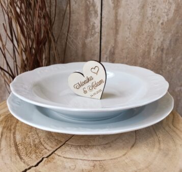 Svadobná menovka v tvare dreveného srdca s menami snúbencov a dátumom svadby – elegantný doplnok na svadobný stôl.