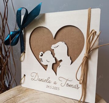 Svadobný drevený fotoalbum s gravírovanými menami a dátumom – romantický dizajn s vyrezaným siluetovým motívom v tvare srdca.