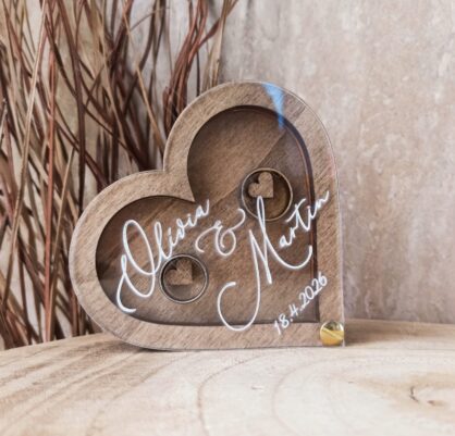 Drevená krabička na prstene v tvare srdca s priehľadným plexi a menami, dátum svadby {{brizy_dc_image_alt entityId=