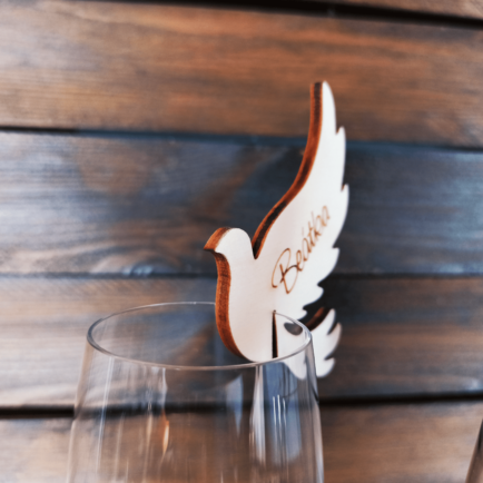 Drevená menovka holubica – elegantná svadobná dekorácia s gravírovaným menom na pohár. {{brizy_dc_image_alt imageSrc=